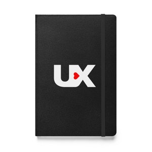 Peut inclure: Un carnet noir avec un logo "UX" blanc et un cœur rouge au milieu du "U".