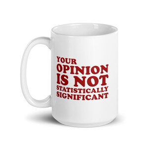 Peut inclure: Une tasse à café en céramique blanche avec un motif rouge qui dit "YOUR OPINION IS NOT STATISTICALLY SIGNIFICANT".