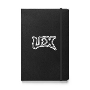 Puede incluir: Cuaderno de cuero negro con una pegatina blanca que dice "UX" en una fuente estilizada.