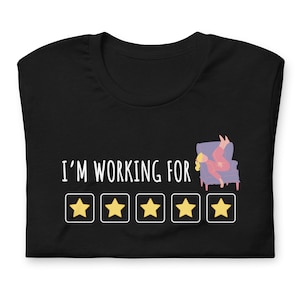 May include: Black t-shirt with the text "I'm working for" and five yellow stars in a row.