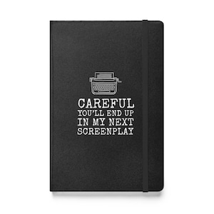 Peut inclure: Un carnet noir avec un dessin de machine à écrire blanche et le texte "CAREFUL YOU'LL END UP IN MY NEXT SCREENPLAY".