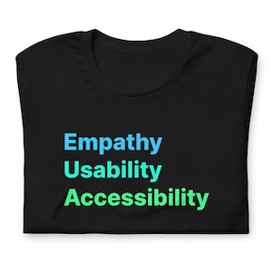 Könnte beinhalten: Schwarzes T-Shirt mit den Worten "Empathie", "Benutzerfreundlichkeit" und "Barrierefreiheit" in Blau und Grün.