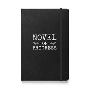 May include: Black leather-bound journal with the text "NOVEL in PROGRESS" in white lettering.