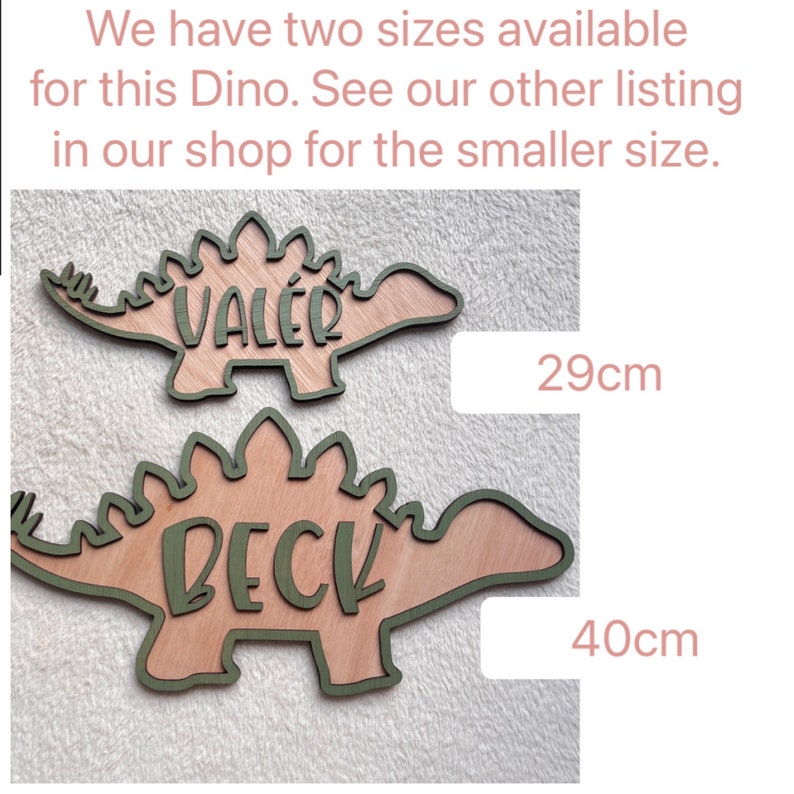 May include: Two wooden dinosaur shapes with names "Val&eacute;r" and "Beck" written on them. The dinosaur shapes are 29 cm and 40 cm in size.