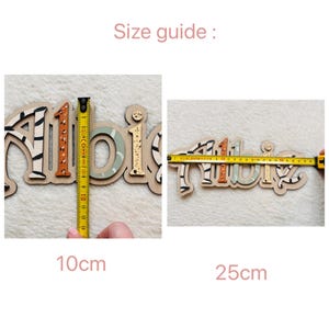 K&ouml;nnte beinhalten: Gr&ouml;&szlig;en&uuml;bersicht f&uuml;r ein Holz-Namensschild mit dem Namen "Albie" in bunten Tierdruckbuchstaben. Das Schild ist 10 cm hoch und 25 cm breit.