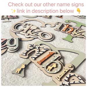 May include: Wooden name signs with a safari theme. The names Cleo, Theo, and Abi are spelled out in layered wood with animal print and giraffe accents.