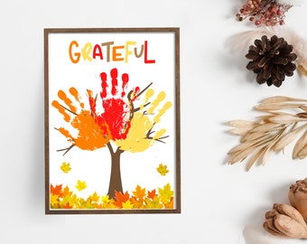 May include: A framed print with the word "GRATEFUL" in colourful letters. The print features a handprint tree with orange, yellow, and red handprints. The tree is surrounded by colourful leaves.