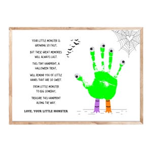 K&ouml;nnte beinhalten: Ein gerahmter Druck mit einem gr&uuml;nen Handabdruck-Monster mit Wackelaugen, einem Spinnennetz und Flederm&auml;usen. Der Text lautet: YOUR LITTLE MONSTER IS GROWING SO FAST, BUT THESE GREAT MEMORIES WILL ALWAYS LAST. THIS TINY HANDPRINT, A HALLOWEEN TREAT, WILL REMIND YOU OF LITTLE HANDS THAT ARE SO SWEET. FROM LITTLE MONSTER TO BIG SOMEDAY, TREASURE THIS HANDPRINT ALONG THE WAY. LOVE, YOUR LITTLE MONSTER.