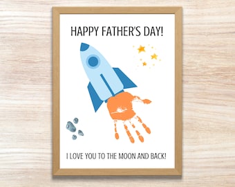 May include: A white card with a blue and orange rocket ship, yellow stars, and gray rocks. The card says "Happy Father's Day!" and "I love you to the moon and back!"