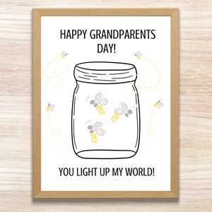 May include: A framed print with the text "HAPPY GRANDPARENTS DAY! YOU LIGHT UP MY WORLD!" features a jar with fireflies. The fireflies are yellow and gray, with dotted lines representing their flight paths. The frame is a light brown color.