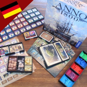 Puede incluir: Un juego de mesa llamado Anno 1800, con una caja azul, verde y blanca que presenta un barco. El juego incluye una variedad de componentes, incluyendo piezas de madera, cartas y un tablero de juego.