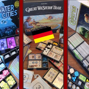 May include: Three different board games with their corresponding game inserts. The games are "Underwater Cities", "Great Western Trail", and "Caverna: The Cave Farmers". The inserts are made of black plastic and have compartments for organizing the game components. The inserts are sitting on a wooden table.