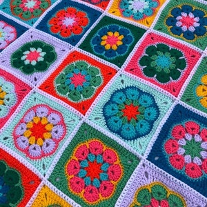 May include: A colorful crocheted blanket made of square patches with a flower design in the center of each patch. The blanket features a variety of colors, including pink, green, blue, yellow, and orange.