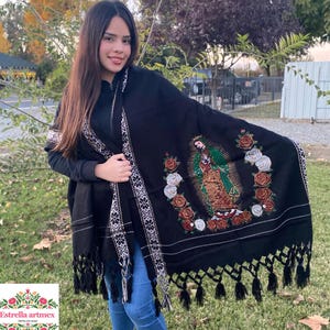 Peut inclure: Châle noir avec bordure blanche et noire et une image brodée colorée de la Vierge Marie entourée de roses.