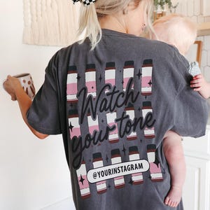 Puede incluir: Una camiseta gris con un gr&aacute;fico de varias botellas y el texto "Watch your tone" y "@yourinstagram".