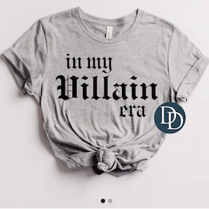 Op de afbeelding: Grijs T-shirt met zwarte tekst die "in my Villain era" luidt.