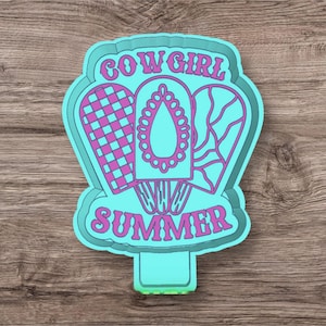 May include: A turquoise blue sticker with a pink outline featuring three popsicle shapes with different patterns. The text "COWGIRL SUMMER" is written in pink letters on the sticker.