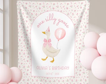 May include: A white banner with a pink floral pattern and a central illustration of a goose wearing a party hat and bow. The text reads "one silly goose" and "Olivia's Birthday, Oct 15th, 2025". Pink balloons are in the foreground.