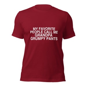 May include: Red t-shirt with white text that reads "My favourite people call me Grandpa Grumpy Pants."