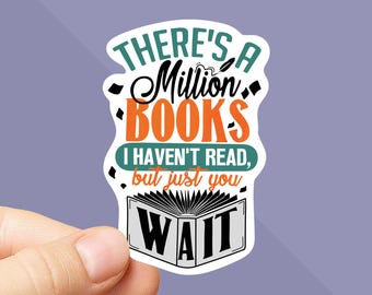 May include: A white sticker with the text "THERE'S A Million BOOKS I HAVEN'T READ, but just you WAIT" in a mix of fonts and colors. The sticker has a book graphic at the bottom and is held by a hand.