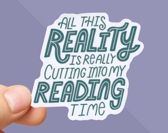 May include: A white sticker with teal lettering. The text reads "ALL THIS REALITY IS REALLY CUTTING INTO MY READING TIME". The sticker is held by a hand against a purple background. The sticker is a fun item for book lovers.