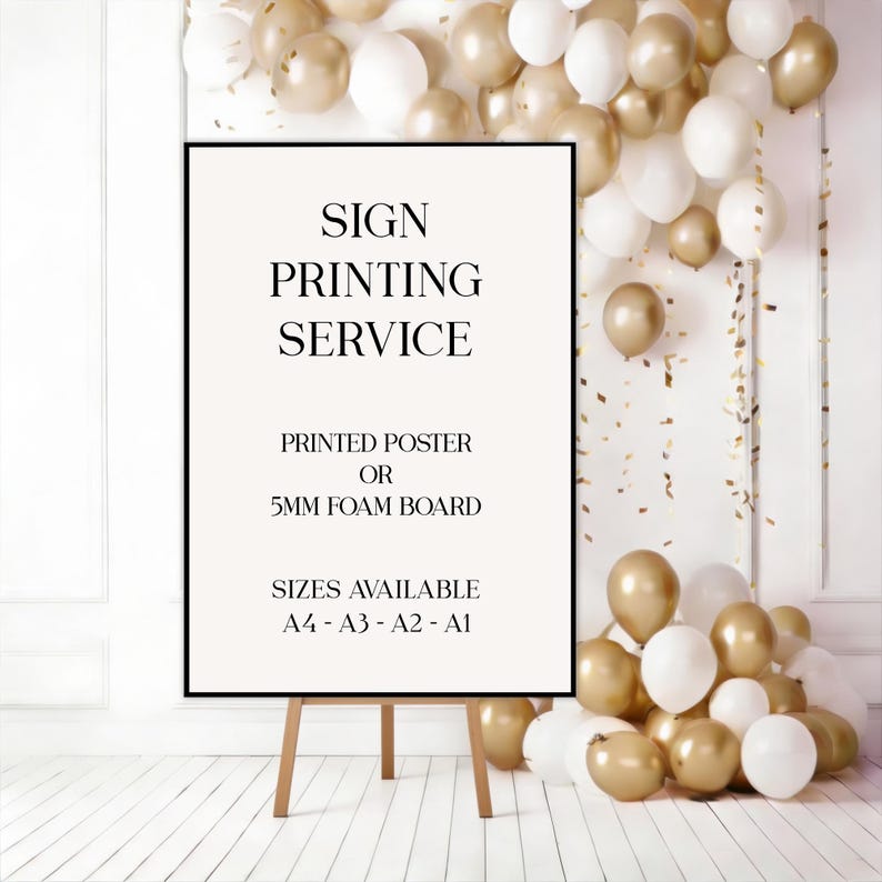May include: A framed sign on a wooden easel, with the text "SIGN PRINTING SERVICE." The sign offers printed posters or 5mm foam boards in A4, A3, A2, and A1 sizes. The background features gold and white balloons.