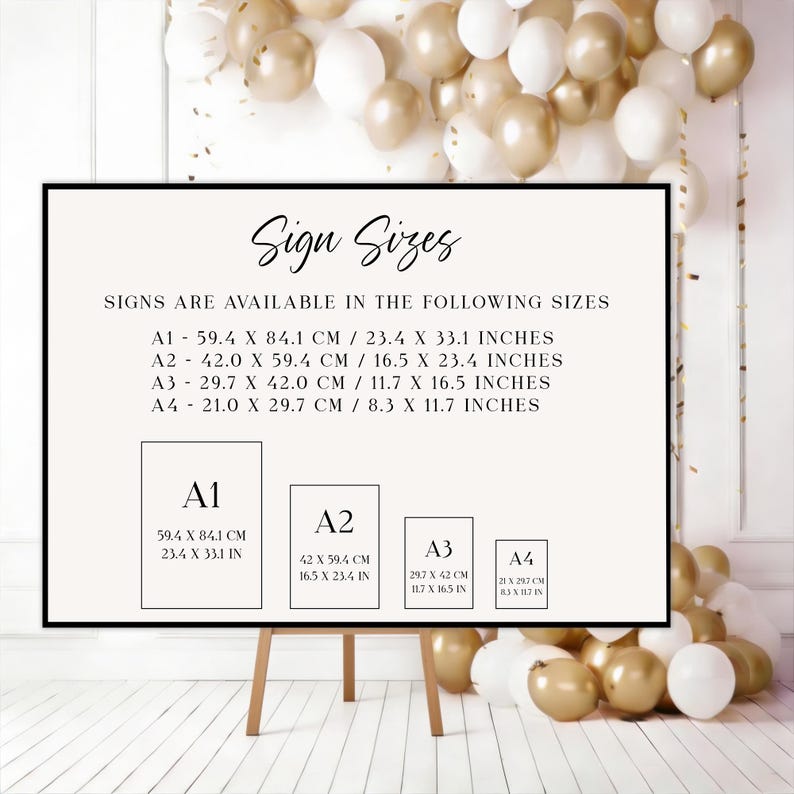 May include: A framed sign on an easel displays sign sizes, including A1 (23.4 x 33.1 inches), A2 (16.5 x 23.4 inches), A3 (11.7 x 16.5 inches), and A4 (8.3 x 11.7 inches). The sign is against a backdrop of gold and white balloons.