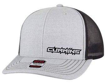 Puede incluir: Una gorra de camionero gris y negra con un logotipo "CUMMINS" blanco bordado en la parte delantera.