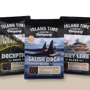 May include: Three bags of Island Time Coffee Company coffee. The bags are black with white text and feature different images. The first bag features a bridge and the text "Deception Dark". The second bag features an orca and the text "Salish Orca Blend". The third bag features a ferry and the text "Ferry Line Blues".