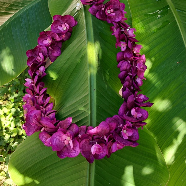 Hawaiianische Blumenkette aus lila Orchideen