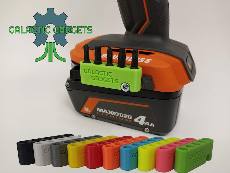 May include: A green 3D printed holder for drill bits, with the text "GALACTIC GADGETS" printed on it. The holder is attached to a black and orange drill battery. The holder is available in a variety of colors, including black, gray, yellow, red, orange, blue, green, and pink.