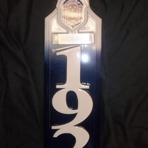 Peut inclure: Une pagaie décorative avec un dégradé blanc et bleu marine. Le haut présente les lettres grecques ZΦB. Le chiffre "1920" est bien en évidence. La section inférieure comprend le texte : "Zeta Phi Beta Sorority Inc."