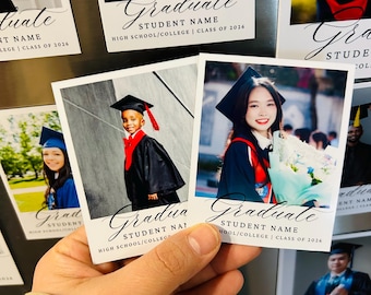May include: A hand holding several graduation photo magnets. Each magnet features a graduate in a cap and gown, with the text "Graduate", "Student Name", and "High School/College | Class of 2026". The photos are in color.