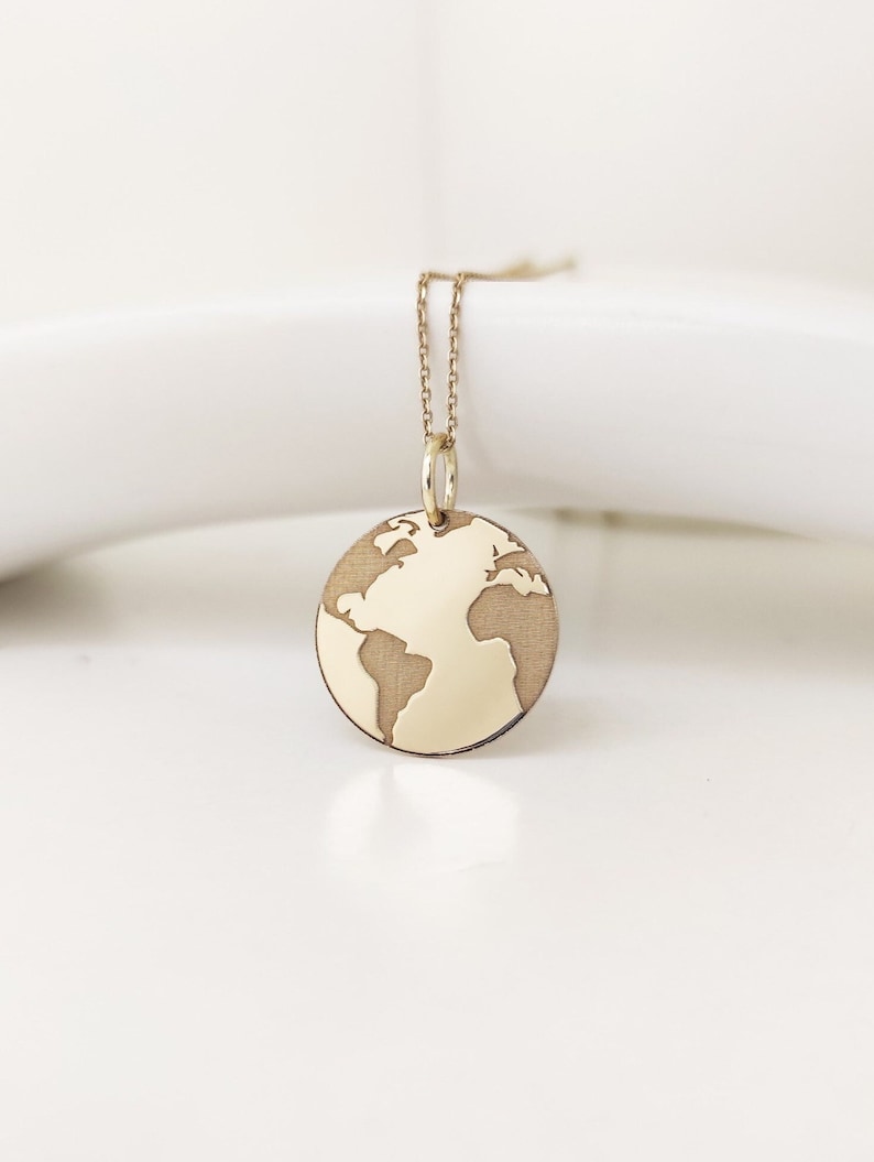 A beautiful earth pendant made out of 14k solid gold, a unique world map design that is perfect for dreamers, travellers, and nature lovers.