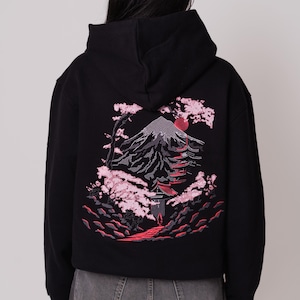 K&ouml;nnte beinhalten: Schwarzer Kapuzenpullover mit einem roten und rosafarbenen Stickmotiv von Mount Fuji, einem Pagodentempel und Kirschbl&uuml;ten.