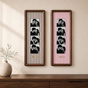 May include: Two vertical rectangular wooden frames containing photo strips of a couple. The left frame has brown and white stripes with the gold letters A M. The right frame has pink and white stripes with the gold letters A heart M.