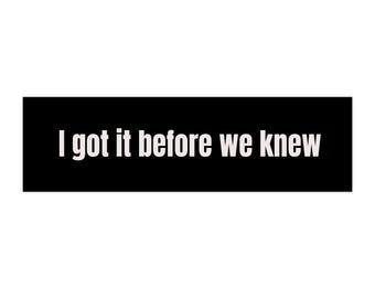 May include: Black rectangular sign with white text that reads "I got it before we knew".