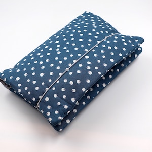 May include: A blue fabric pouch with a white polka dot pattern. The pouch is folded and has a gray zipper.