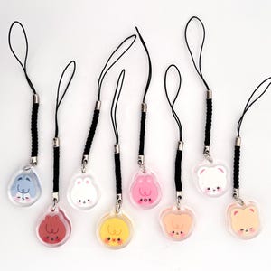 May include: Eight colourful acrylic charms with cartoon animal faces, each attached to a black lanyard. The charms feature a variety of animals in shades of pink, yellow, orange, white, and blue.