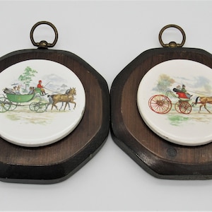 Peut inclure: Deux plaques murales en bois avec des carreaux de céramique blancs représentant un carrosse tiré par des chevaux avec des passagers. Les carreaux ont un carrosse vert, des chevaux bruns et un fond vert.