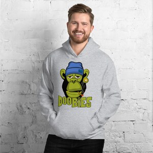May include: A grey hooded sweatshirt featuring a green cartoon monkey wearing a blue hat and smoking a cigarette. The text "DOOBIES" is printed below the monkey.