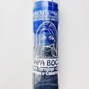 May include: A blue and black glass candle with white text that reads "SHUT UP" and "SILENCE PEOPLE TALKING BEHIND YOU." The candle also features a graphic of a woman's face with her mouth covered and the words "TAPA BOCA."