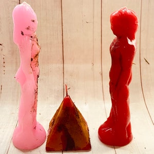 以下が含まれることがあります： 人間の姿をしたろうそくが3本。ろうそくはピンク、赤、茶色です。ピンクと赤のろうそくは直立しており、茶色のろうそくはピラミッドの形をしています。