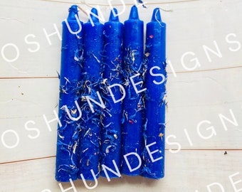 May include: A set of six blue candles with dried flowers embedded in the wax. The candles are arranged in a row and are all the same size.