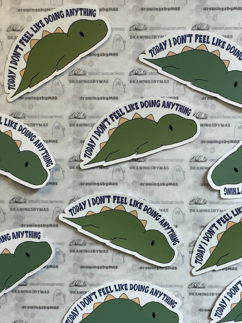 Puede incluir: Una colecci&oacute;n de pegatinas con un dinosaurio verde con una espina dorsal marr&oacute;n claro. El dinosaurio est&aacute; tumbado y el texto "TODAY I DON'T FEEL LIKE DOING ANYTHING" est&aacute; impreso alrededor del dinosaurio. Fondo blanco.