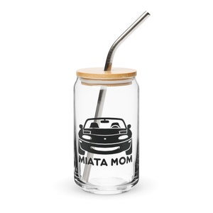 Peut inclure: Un gobelet en verre transparent avec un couvercle en bambou et une paille en acier inoxydable. Le gobelet a une silhouette noire d'une voiture Miata et le texte "MIATA MOM".