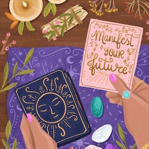 Op de afbeelding: Illustratie van een tarotkaartleesset. Een kaartspel met een zonontwerp, een kaart met de tekst "Manifest your future", kristallen, kaarsen en een smudge stick zijn gerangschikt op een paarse doek.
