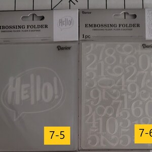 May include: Two clear plastic embossing folders for crafting. The folder on the left has a design of the word "Hello!" in a speech bubble. The folder on the right has a design of various numbers. The folder on the left is labeled "7-5" and the folder on the right is labeled "7-6".