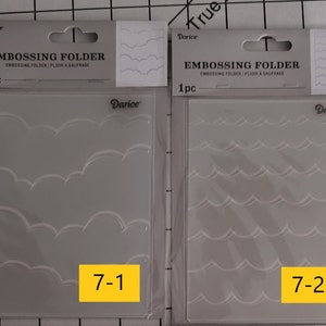 May include: Two clear plastic embossing folders with a white scalloped design. The folder on the left has a larger scalloped design and is labeled "7-1". The folder on the right has a smaller scalloped design and is labeled "7-2".
