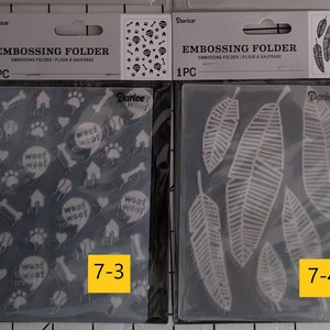 May include: Two clear plastic embossing folders, one with a paw print, bone, and house pattern and the text "woof woof" and the other with a feather pattern. The folders are labeled "7-3" and "7-4" and are packaged with a Darice header card.